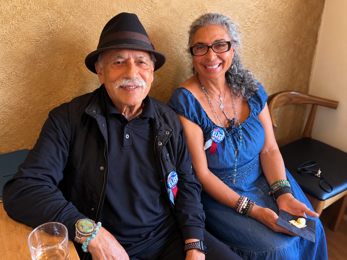 Two supporters seated together, both wearing Vote Elise buttons
