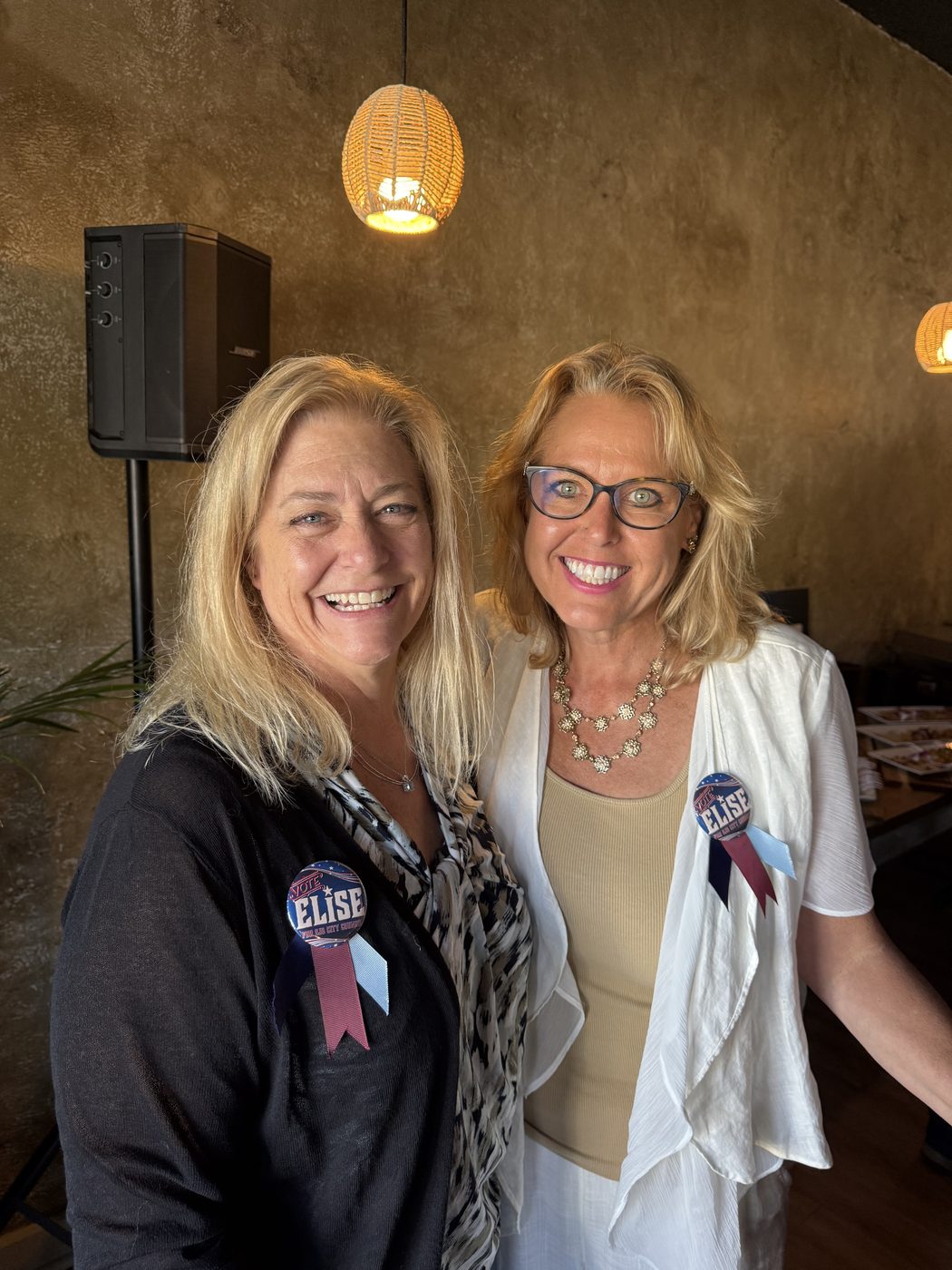 Two supporters wearing Vote Elise buttons at the campaign launch party