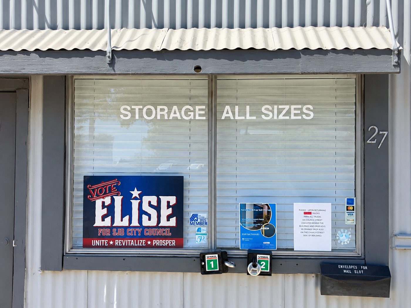 A Vote Elise sign in the window of a local storage business