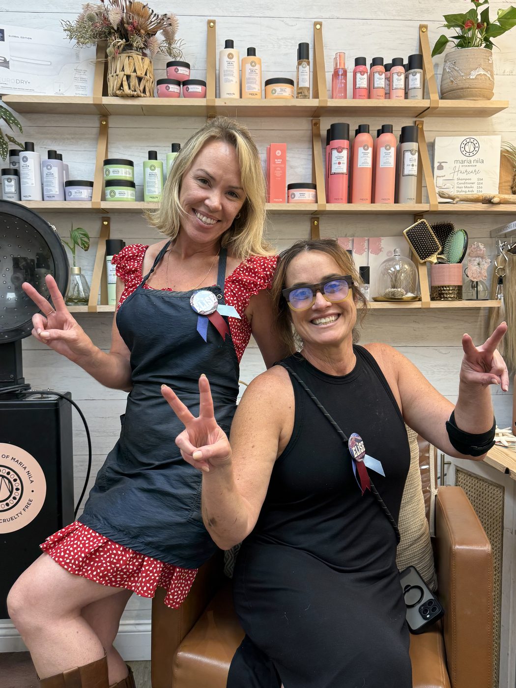 Two supporters at a salon wearing Vote Elise buttons