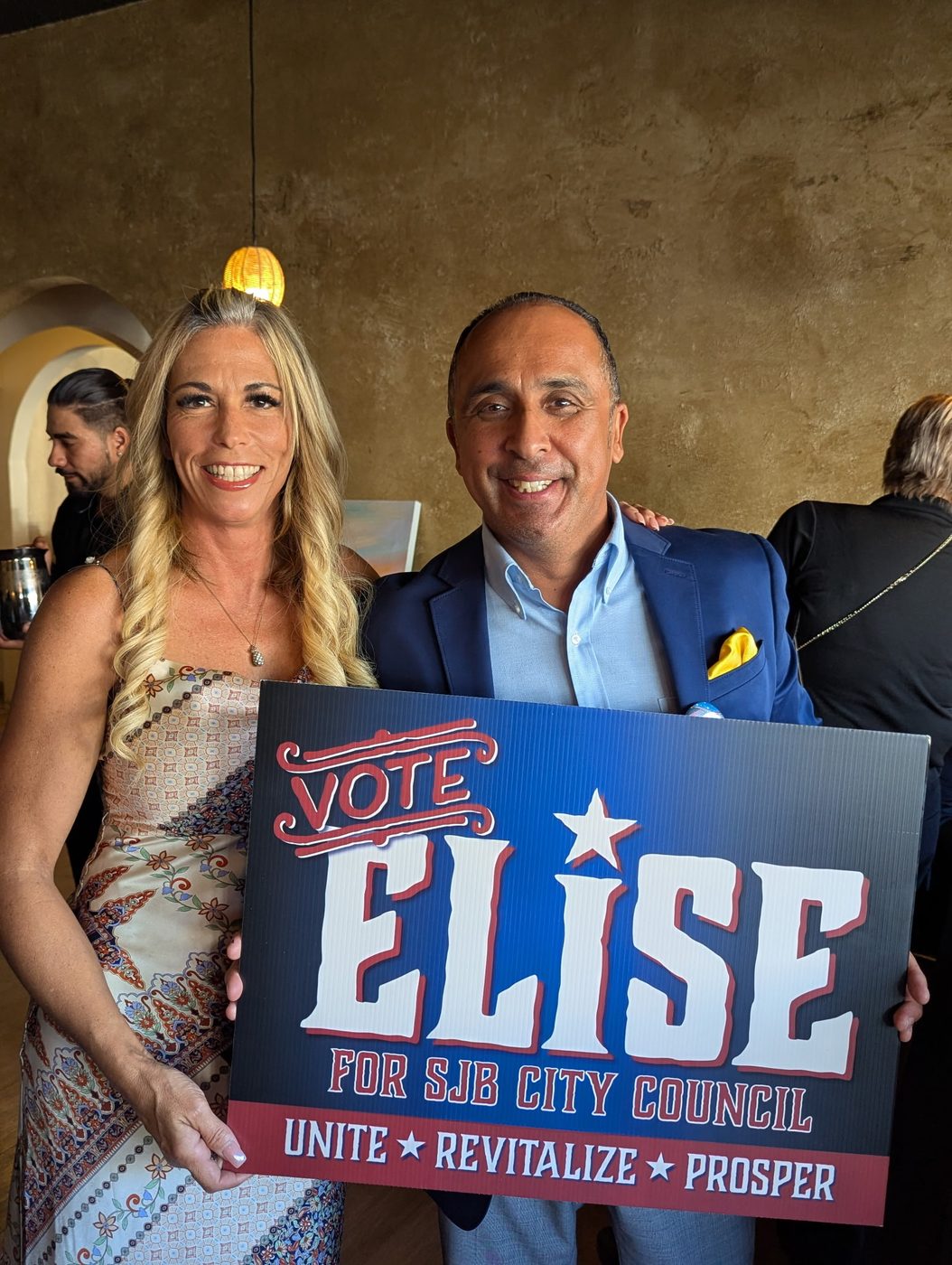 Two supporters holding a Vote Elise for SJB City Council sign at the launch party